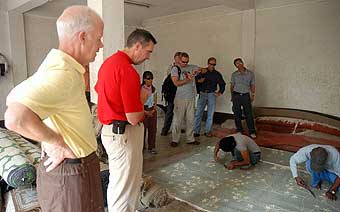 Group watching carpet making by hand