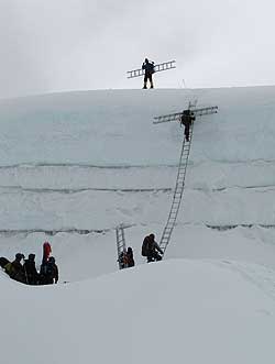 Climbing Sherpas moving ladders higher on Everest