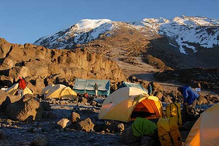 The team at Kosovo Camp looking up at the summit of Kilimanjaro