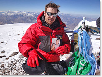 Todd on the summit of Aconcagua holding a picture of girlfriend, Heather