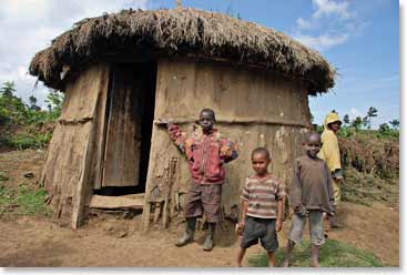 The guide shows the group a typical Massai hut in which they live