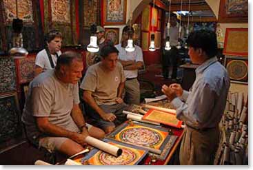 George and Mitchell shop for thankas. A thanka is a hand - painted Tibetan painting usually describing Buddhist stories