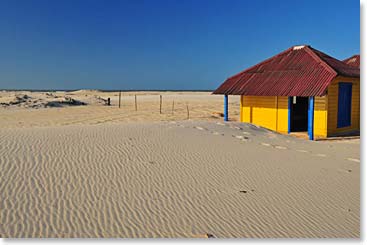 The scenery at the dunes is made more colorful by the scattered human structures