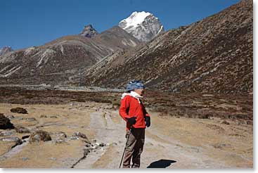 Leland stands along the trail with his mountain, Lobuche Peak above