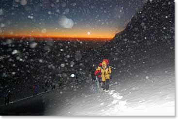 After the summit team started  their climb in the dark, the sun began to rise through the snowfall
