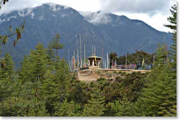 A chorten stands among the trees in the forest.
