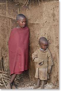 Two Masai children in front of their Boma (house)