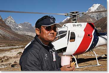 Pema Sherpa, the pilot, took time for a cup of tea and a snack with his rotor still turning