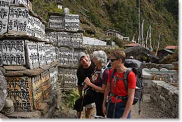 The group stops to look at the Mani Walls. Mani Walls are made up of stones that are placed together along the trail and are offerings to the deceased.
