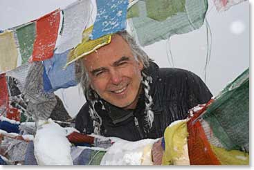 George F. peaking between the prayer flags at the Gokyo Ri summit