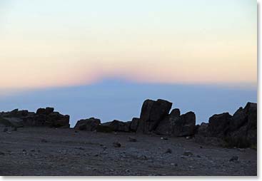 Uhuru Peak, the top of Kilimanjaro, casts a shadow across the horizon.s