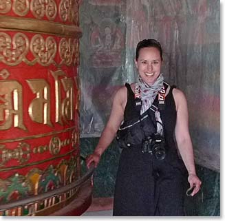 Maya standing with a large prayer wheel
