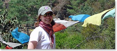 Kerri poses with some prayer flags blowing in the wind.