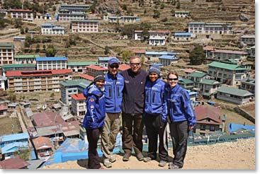 The team stands above the colorful rooftops of Namche