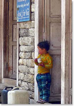 A local Sherpa child watches life go by from his doorstep.