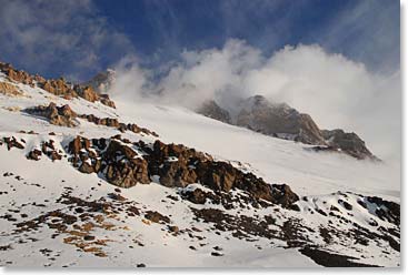 The winds blowing snow from the terrain that lies ahead