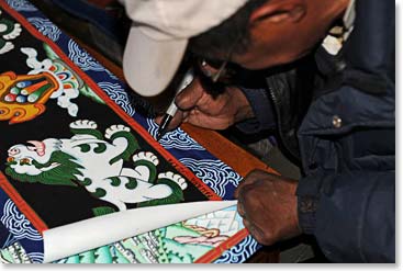 Ang Passang signing one of his Thanka paintings