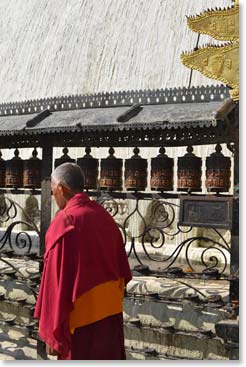 A monk turning prayer wheels – always turn them clockwise