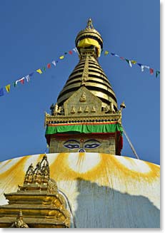 A golden stupa stands tall against the blue sk