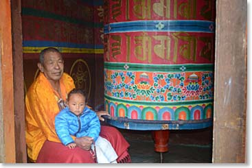 There are prayer wheels all along the trail, big ones and small ones.  They all spin; here a lama holds a small child as he sends the prayer wheel on endless clockwise cycles.