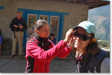 One of the women puts a flower in Jenny’s hair.