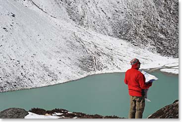 A trekker enjoys the view of the turquoise lake near our base camp.