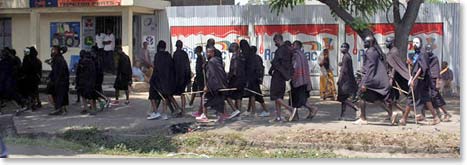 Maasai boys with white faces and wearing black