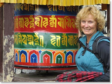 Wendy pauses by a prayer wheel along the trail