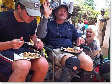 Bill waving hello while he, Robert, and Terri enjoy their meal