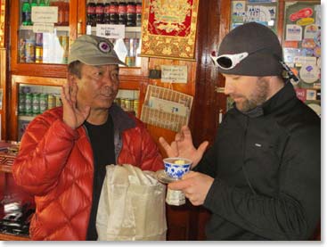 Sherap shows Steve how to offer a bit of Chang to the gods before he sips.