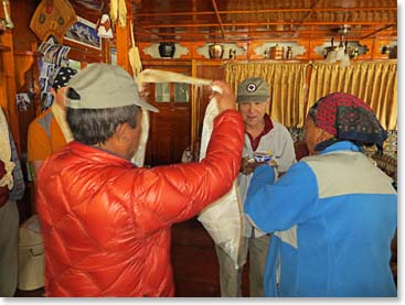 Wally Berg about to be blessed by Sherap. Wally and Sherap cannot remember the number of times that he has been given a Khata upon leaving Panaroma lodge on journey.