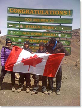 The Janmohamed family on Stella Point with their Canadian flag
