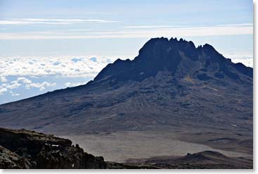 Here is an image of Mawenzi from our High Camp. Mawenzi is the third highest peak in Africa after Kibo and Mount Kenya. Kilimanjaro is composed of three volcanic cones – Kibo,  Uhuru Peak, the highest point on Kibo’s crater rim  at 5,895 m;( 19,341 ft.); Mawenzi at  5,149 m; (16,893 ft).; and Shira at 3,962 m; (13,000 ft.)   Of Kilimanjaro’s three peaks, Mawenzi and Shira are extinct, while Kibo is dormant; steam and sulfur are still emitted. 