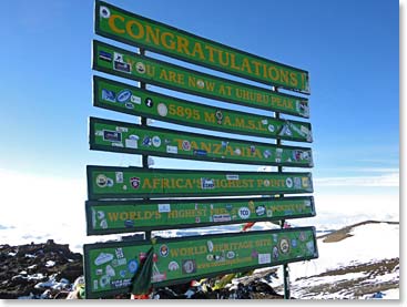 This green and yellow metal plastic looking Kilimanjaro sign replaced the old one in January 2012. Gone was the rustic weathered sign…Now, after 2 years of complaints sent to Kilimanjaro National Park, the park decided to return to the old look.