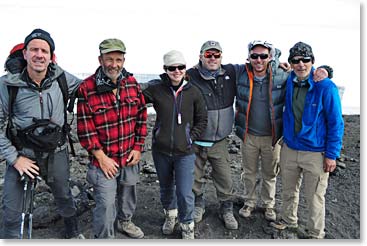 The whole team stands on the summit of Kilimanjaro