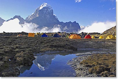 Beautiful reflections of Kantega towering behind base camp