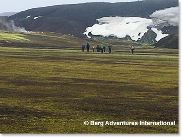 Team trekking with steam vents on the left